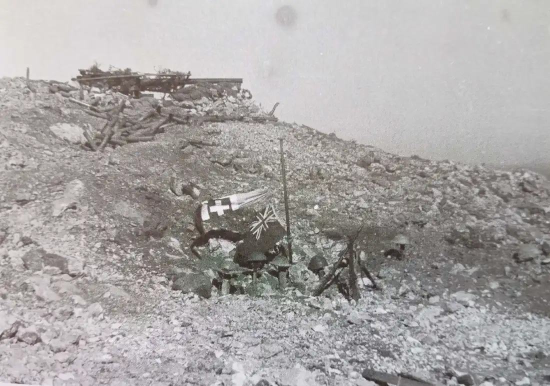 : A German photo showing a communal grave below gun No. 4 of PL 127, Meraviglia, where two Italian and four British helmets indicate at least six men were buried here.